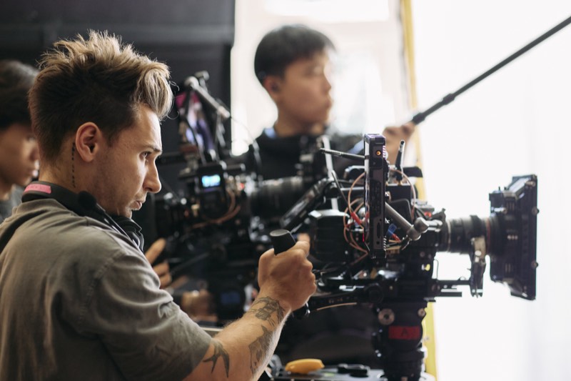 Crew setting up lighting and reflectors for an outdoor shot.