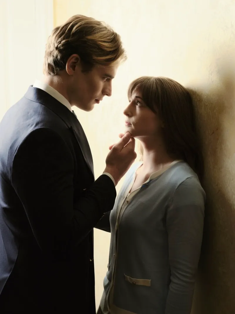 Unit still of a man in a dark suit lifting a woman's chin against a plain wall.