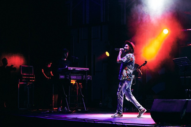 Vocalist and guitarist performing together on an outdoor festival stage.