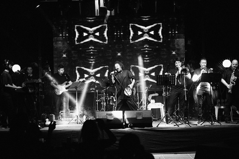 Vocalist and guitarist performing together on an outdoor festival stage.