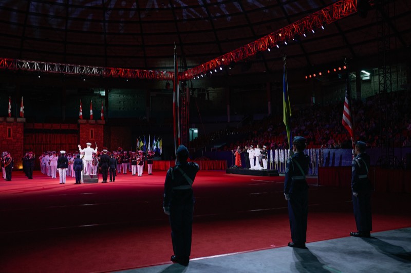 Performers on stage during a large ceremonial event.