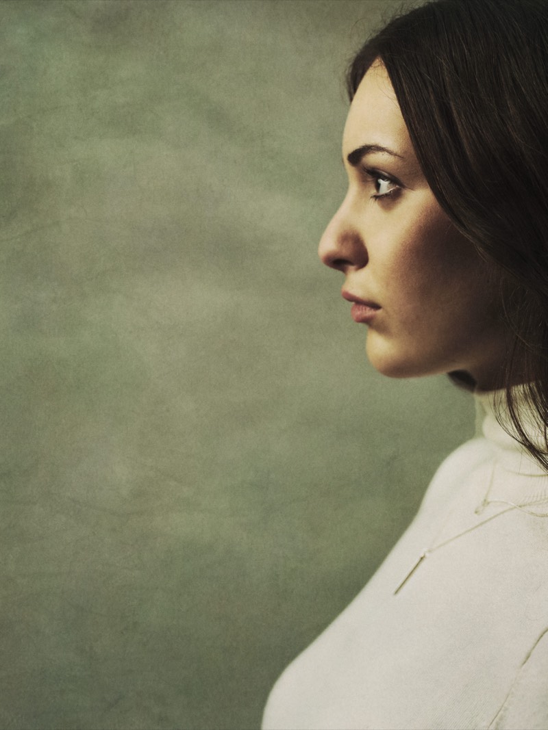 Editorial portrait with muted warm tones and a shallow depth of field.