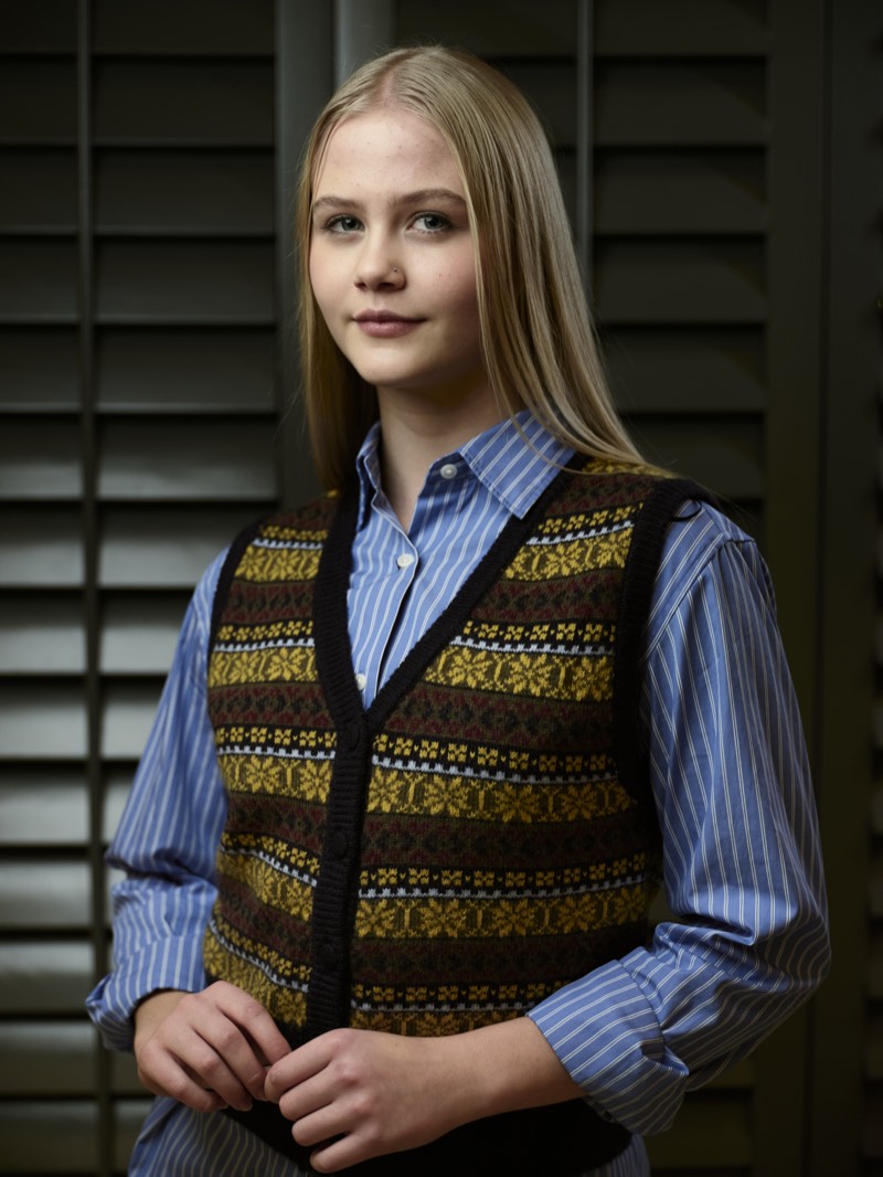 Professional portrait lit with a single soft key light, shoulders square to camera.