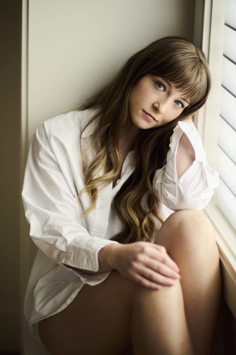 Editorial portrait with muted warm tones and a shallow depth of field.