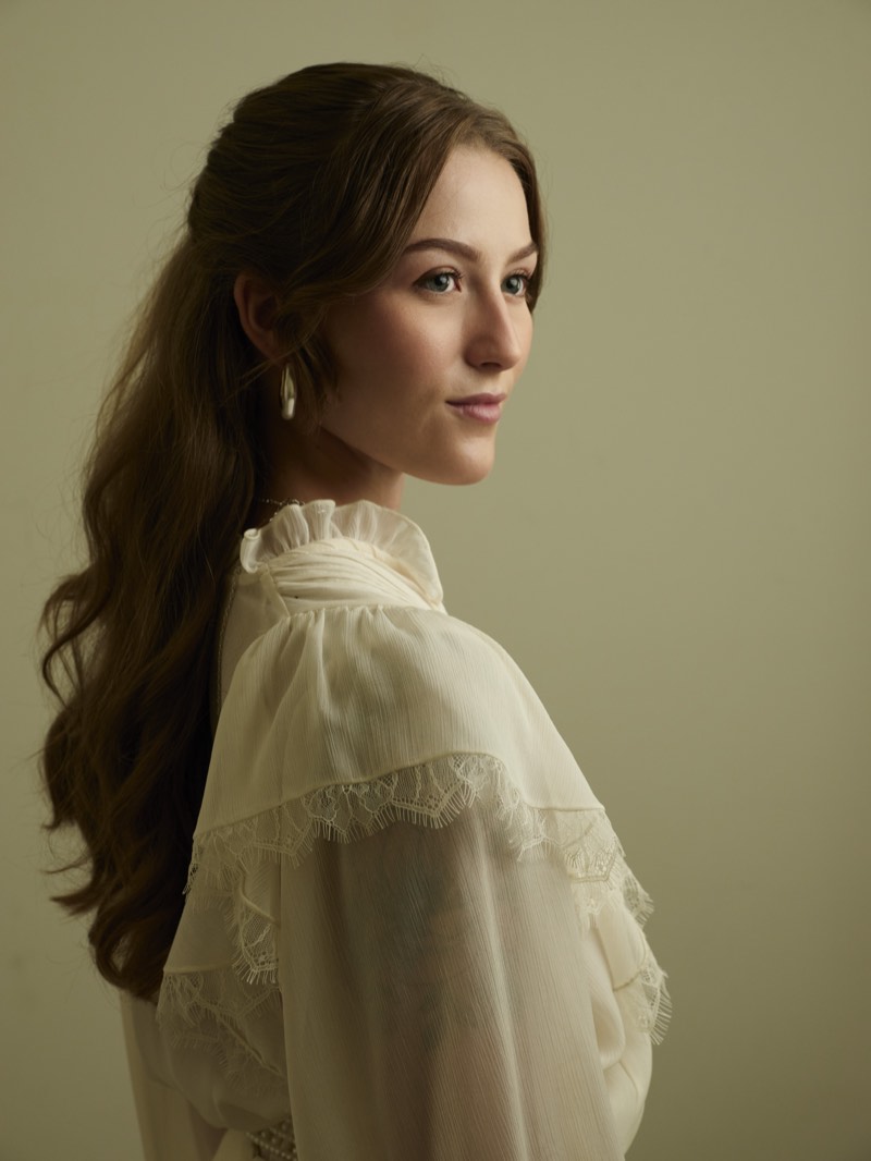 Professional portrait lit with a single soft key light, shoulders square to camera.