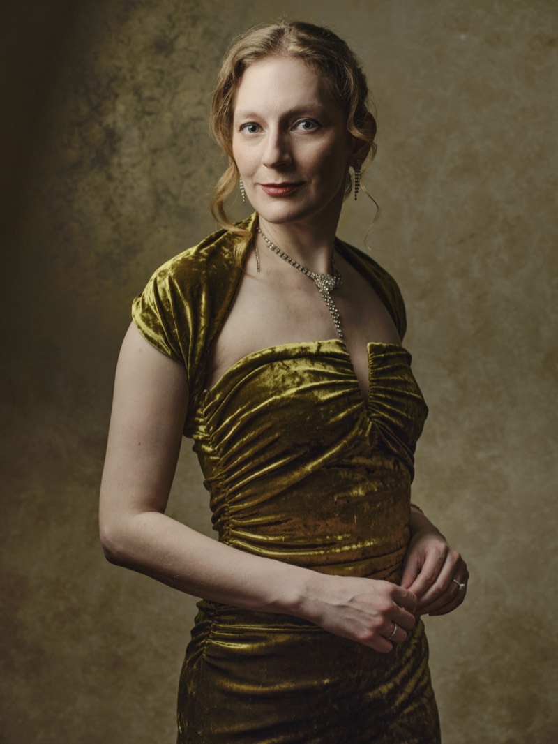 Professional portrait lit with a single soft key light, shoulders square to camera.