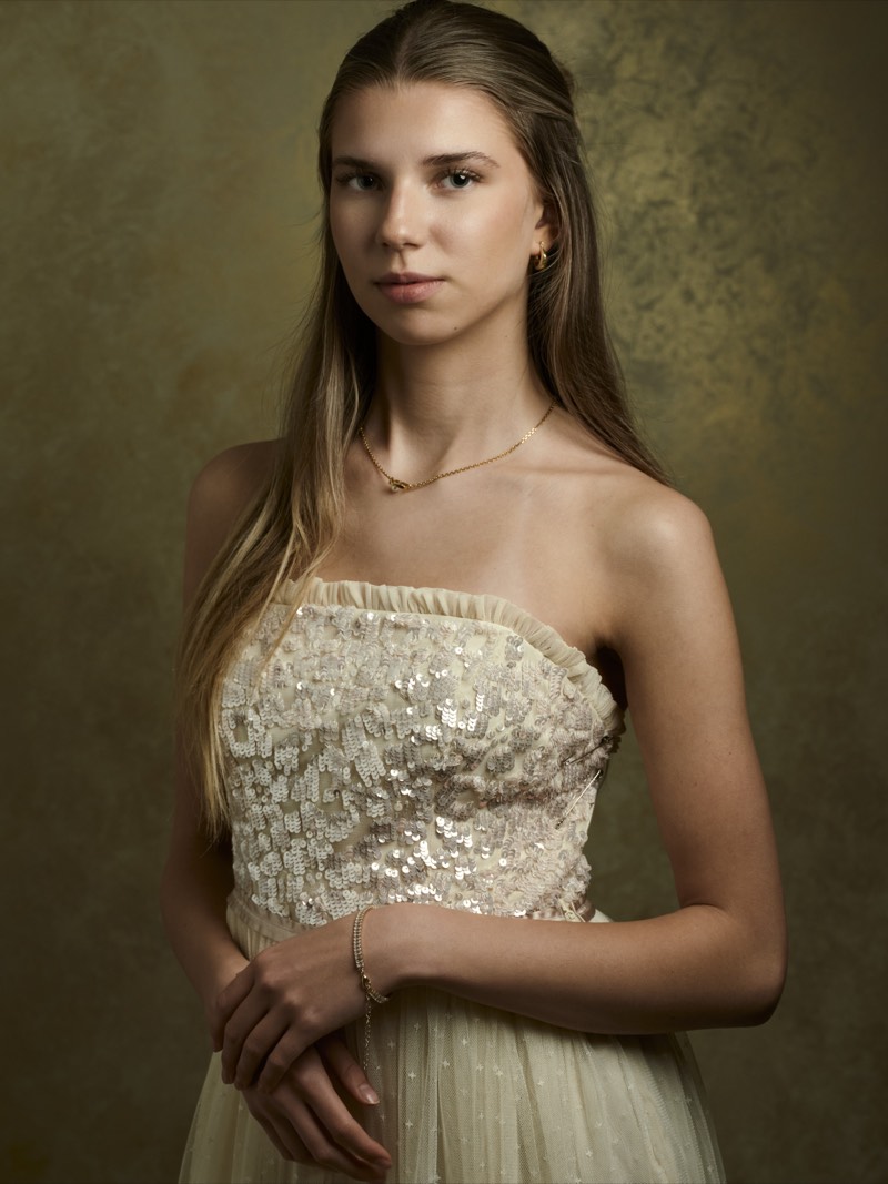 Professional portrait lit with a single soft key light, shoulders square to camera.