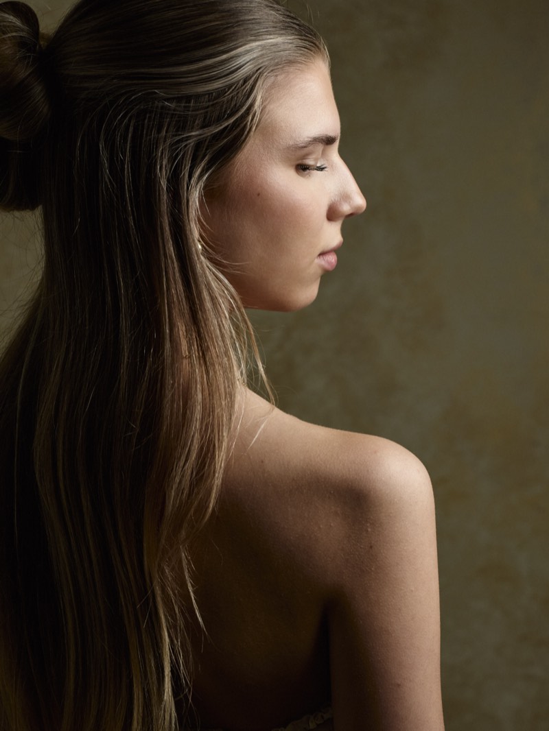 Editorial portrait with muted warm tones and a shallow depth of field.