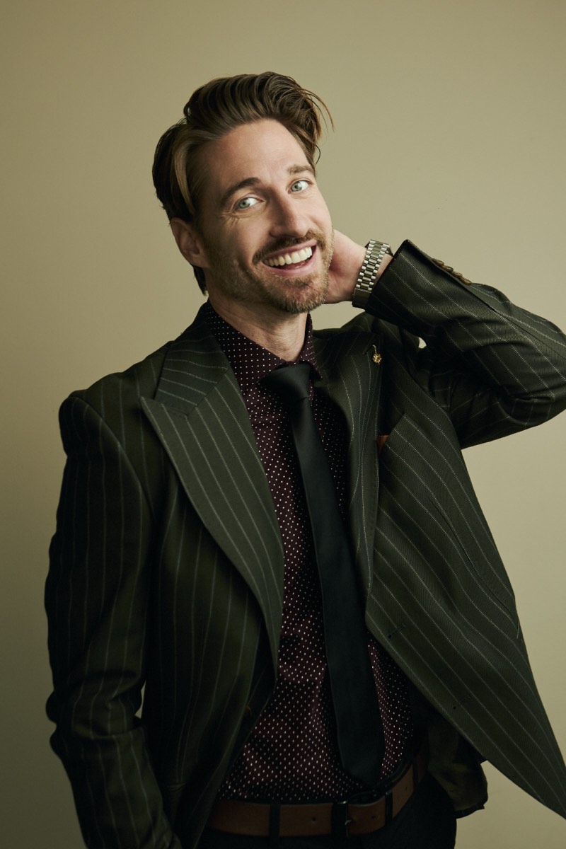 Professional portrait lit with a single soft key light, shoulders square to camera.