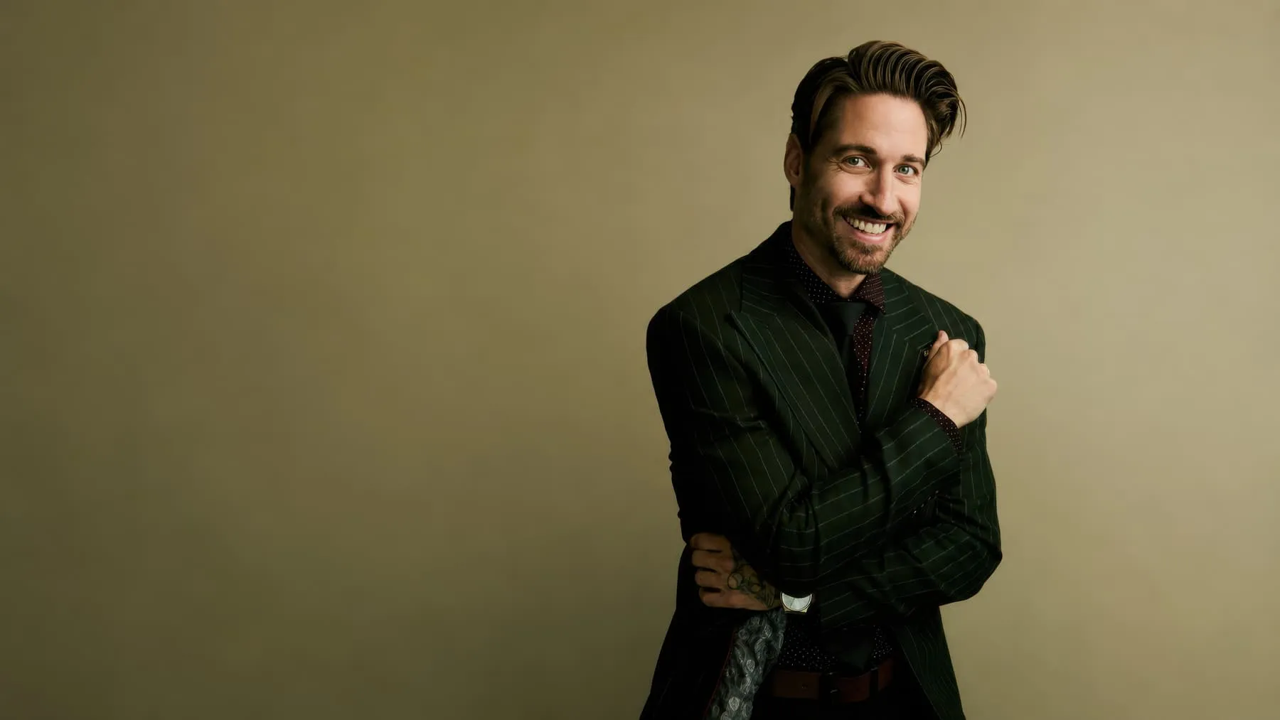 Studio portrait of a man in a pinstripe suit against a warm backdrop, photographed in Vancouver.