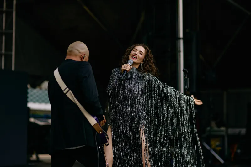 MAKENZA sings with her eyes closed, the silver fringe of the dress swinging out.