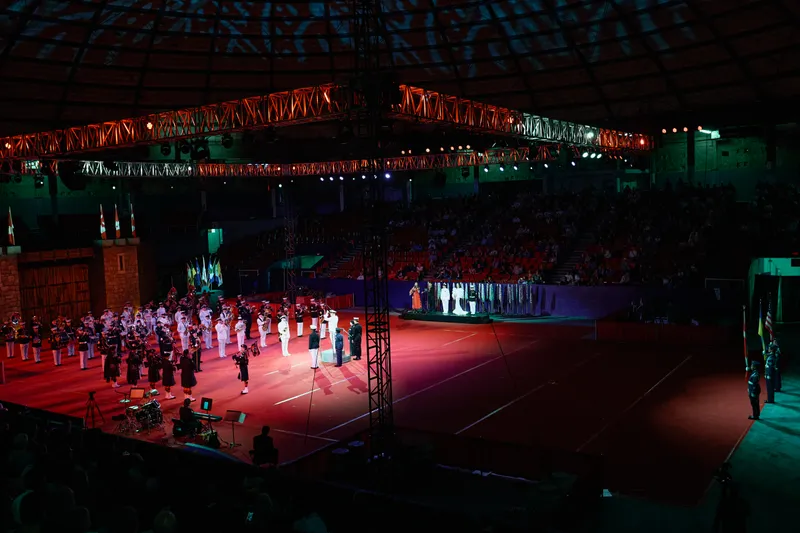 The full arena at the end of the show, the cast lit on the floor and the crowd in the stands.