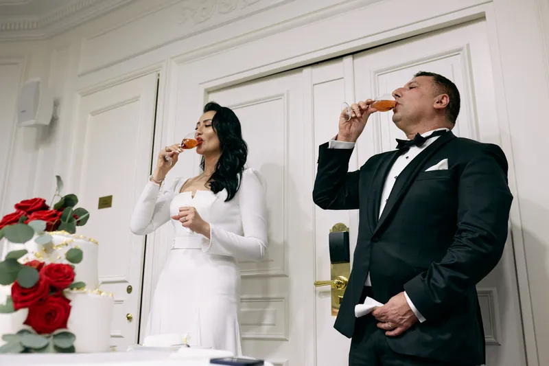 Michael and Julie drink the toast, eyes closed, in front of the red roses.