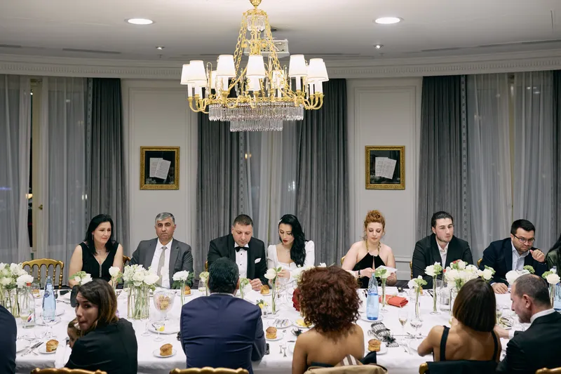The dinner seen from the head of the table, guests turned towards each other.