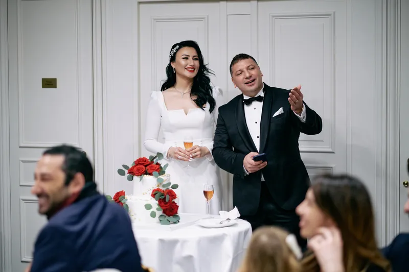 Michael gives his speech with his arm raised, Julie smiling beside him.