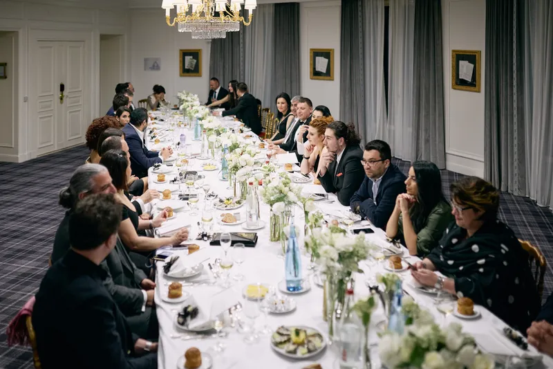 The long dinner table seen from one end, guests seated along both sides.