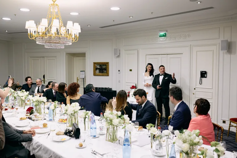 The guests at the long table turn towards the couple during the speeches.