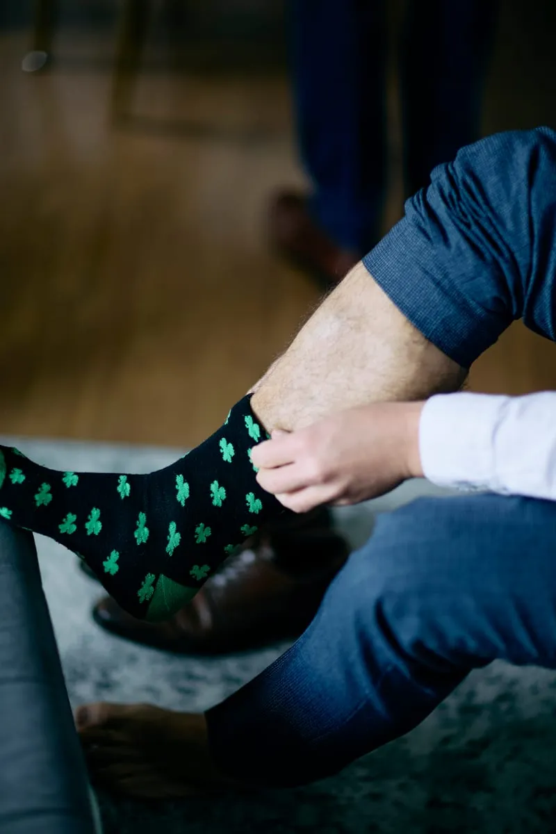Dress shoes going on over cactus-print socks.