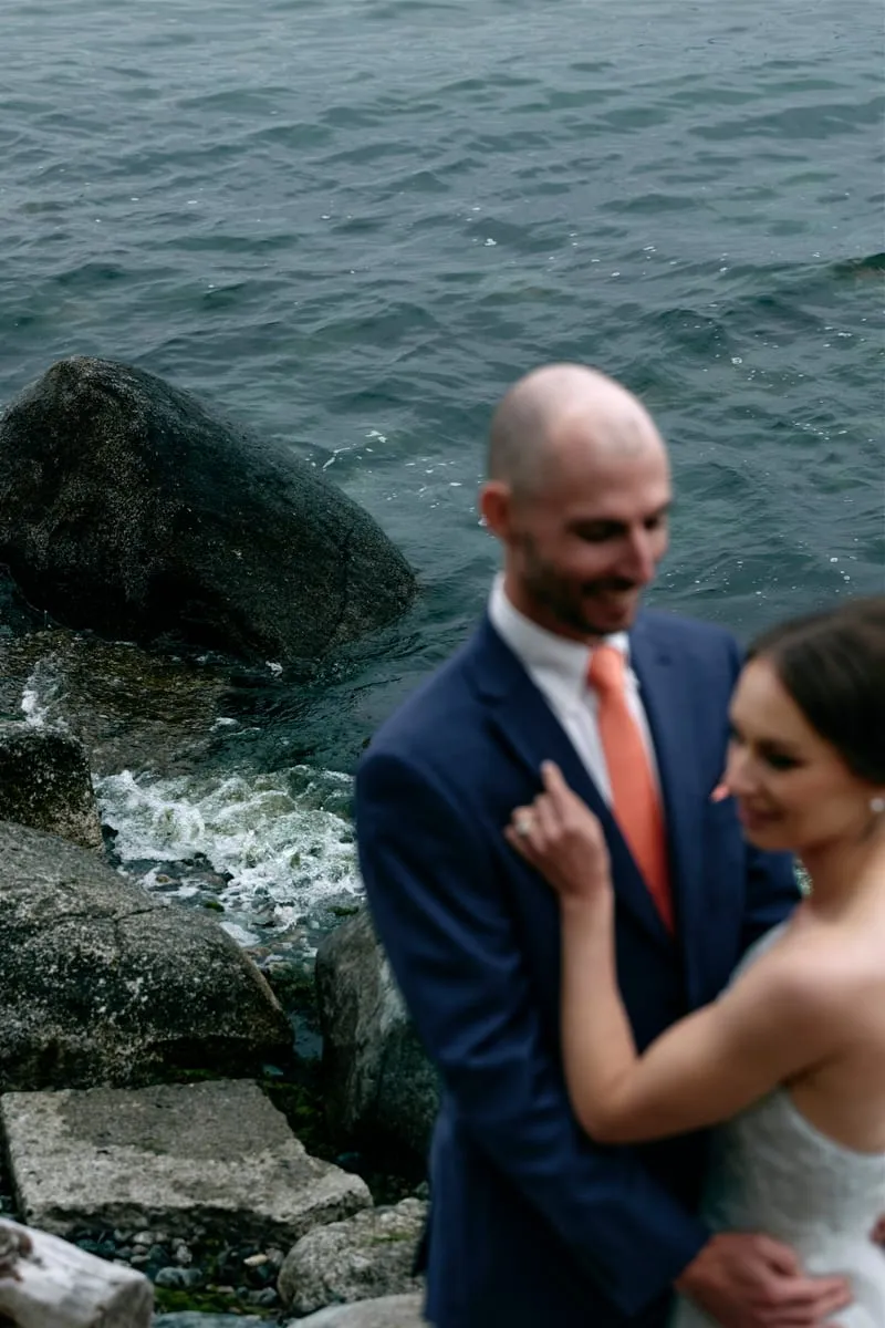 Olivia laughing on the shore, James's hand at her waist.
