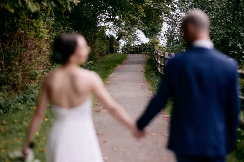 Walking back up the path, hands linked, seen from behind.