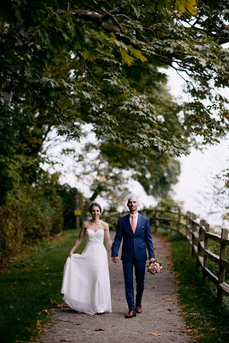 Olivia and James walking towards the camera along the path, hand in hand.