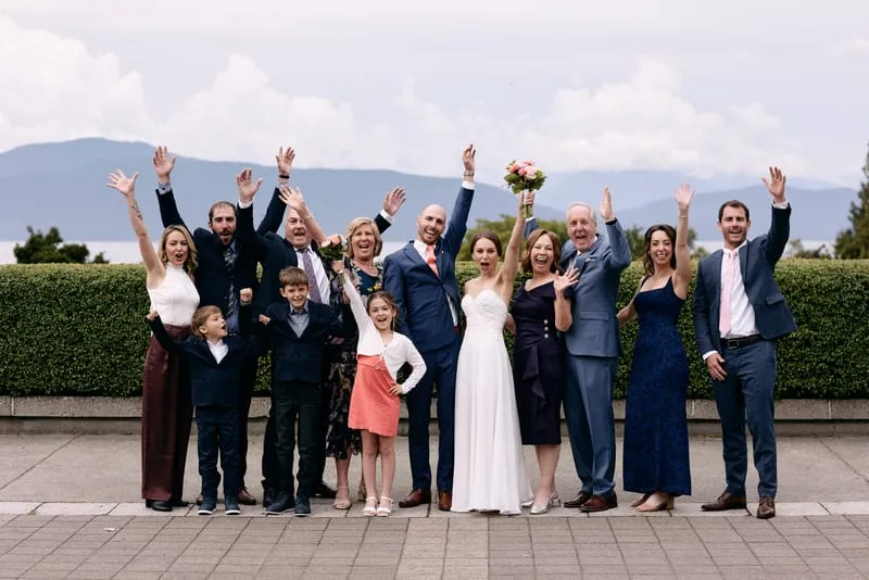 Family on the terrace with their arms in the air, mountains behind.