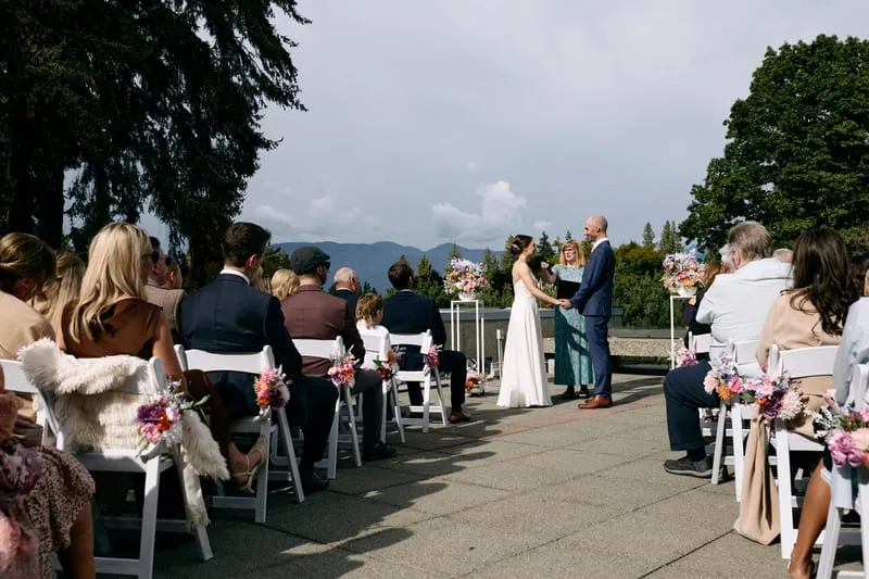 The ceremony seen from behind the guests, trees and mountains ahead.