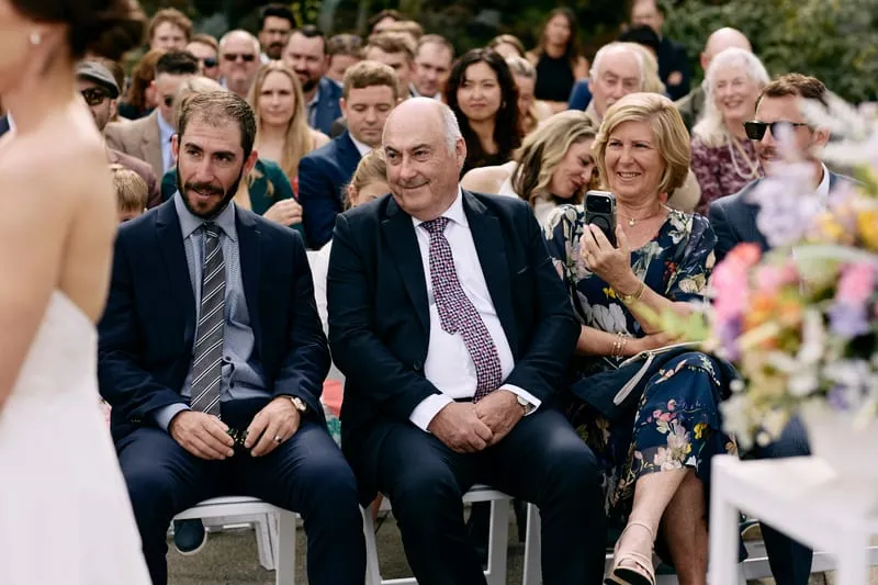 Guests in the front rows laughing during the vows.