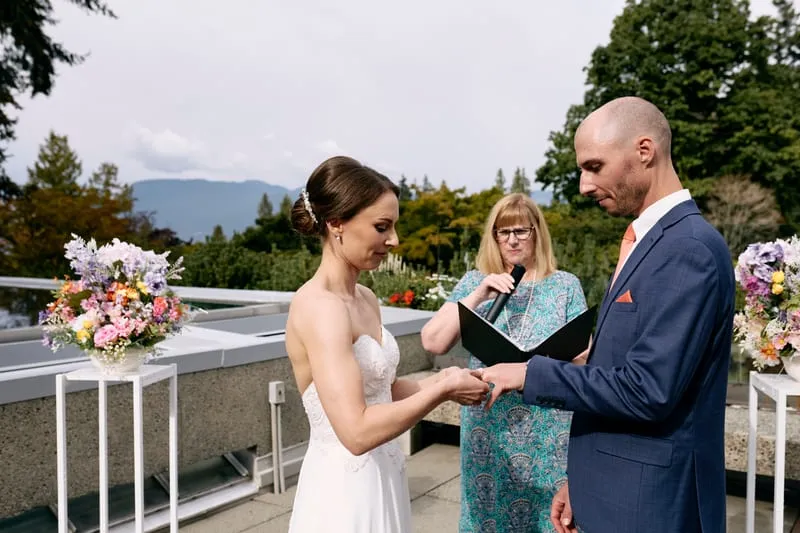 Olivia putting the ring on James's finger.