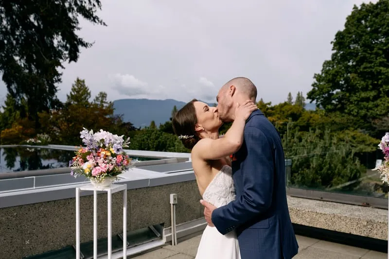 The first kiss as a married couple, the mountains behind.
