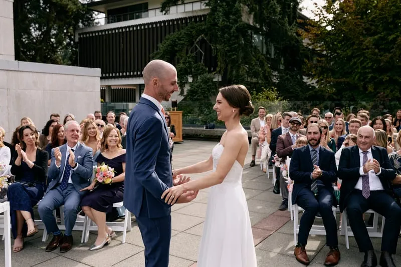 Guests applauding as Olivia and James turn to them.