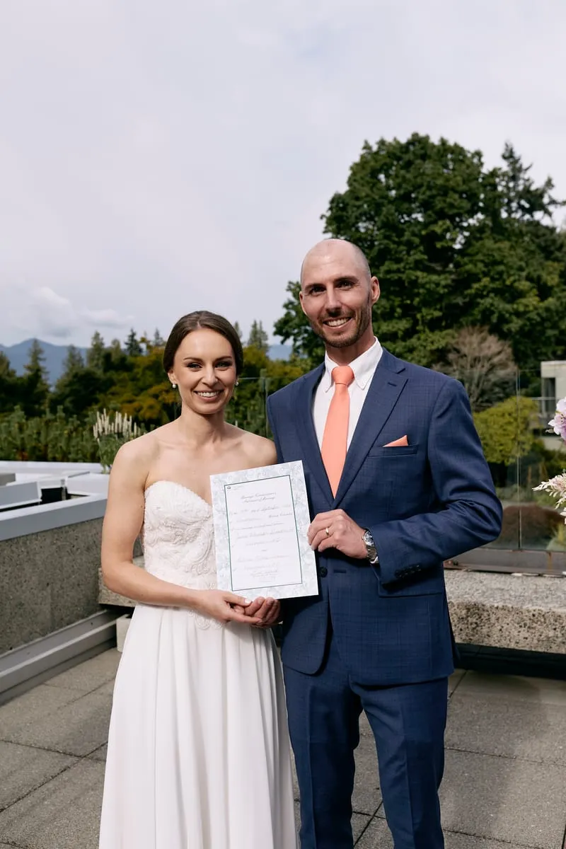 Olivia and James holding up the signed certificate.