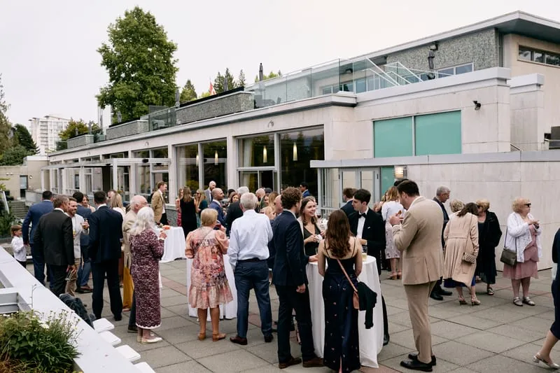 Guests gathering on the terrace beside the building.