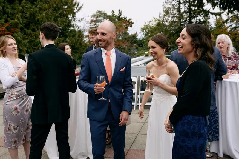 Olivia and James laughing with friends on the terrace.