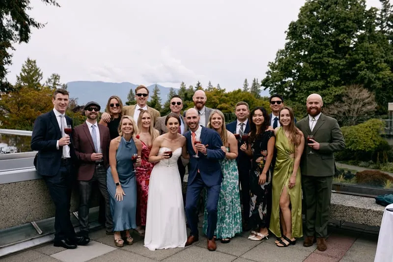 Olivia and James with a crowd of friends along the terrace railing.