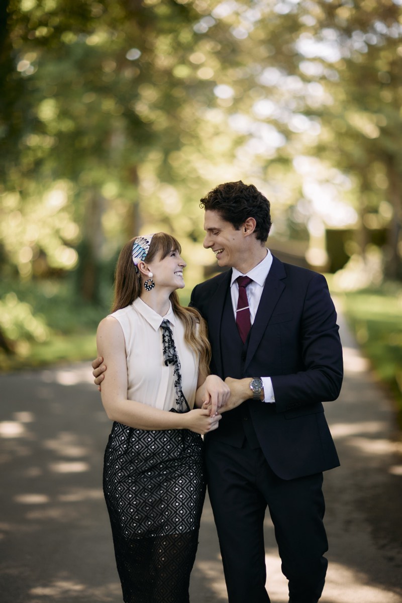 Couple embracing in a chateau garden, photographed from a distance.