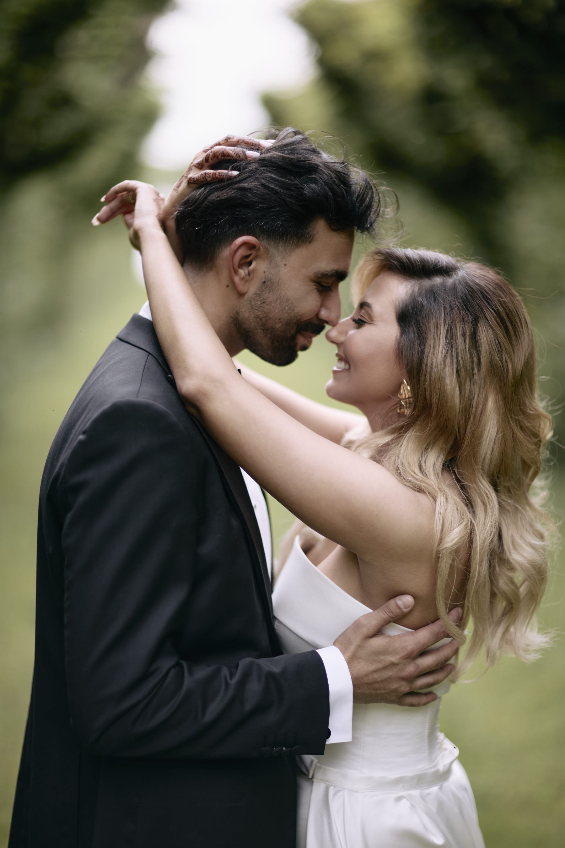 Bride and groom in a wheat field beneath a dramatic cloudy sky.